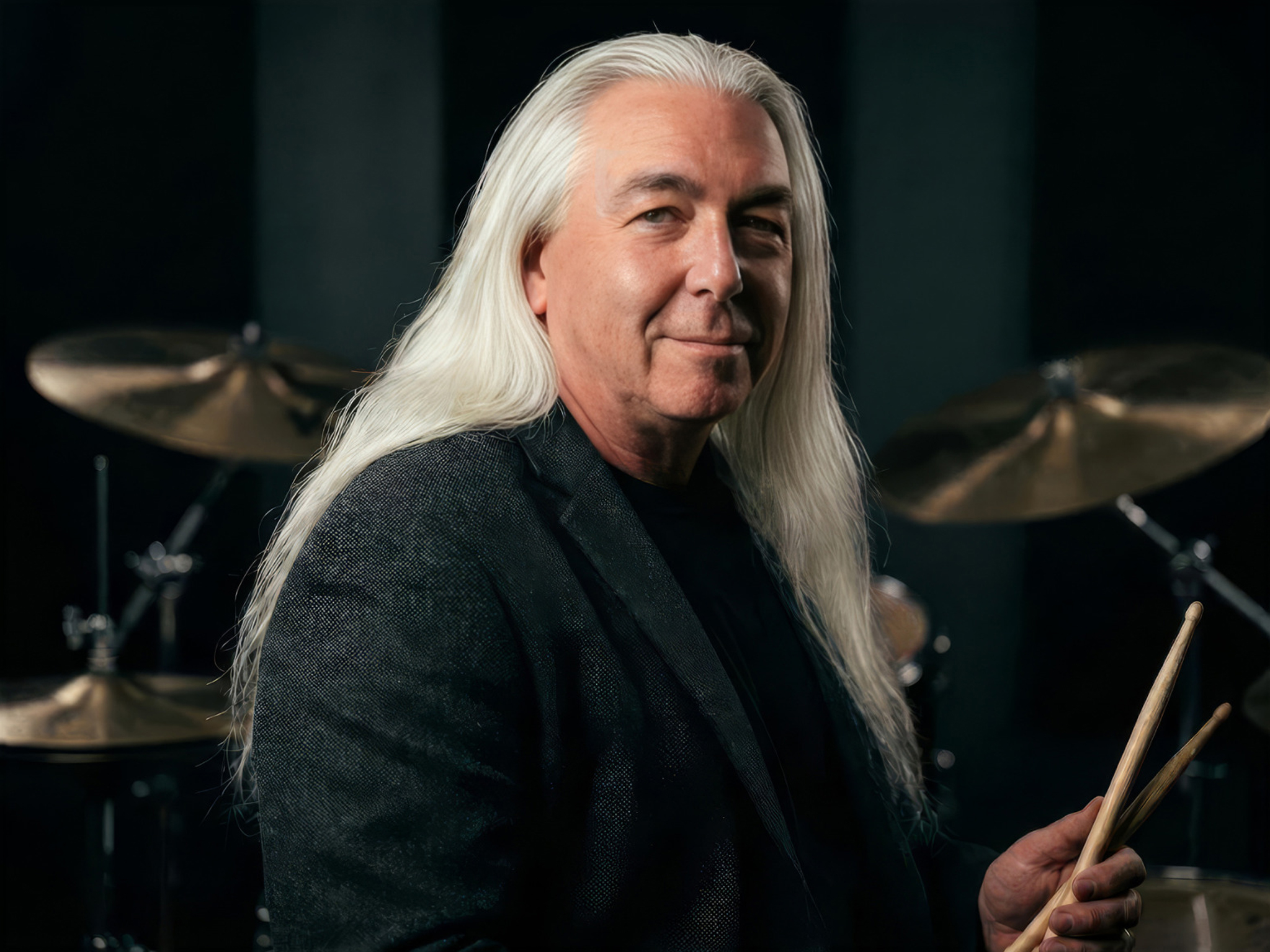 Tommy Civitillo seated at a drum kit holding drumsticks